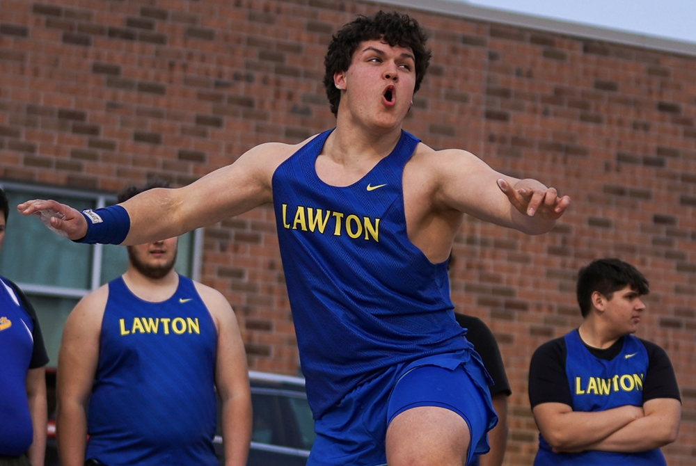 Lawton's Mason Mayne watches one of his throws during a meet.