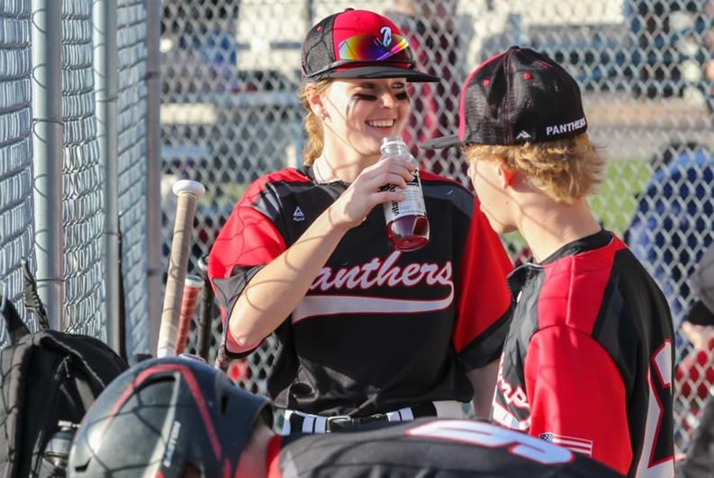  Alisha Gahn hangs out with her baseball teammates in the dugout this season.