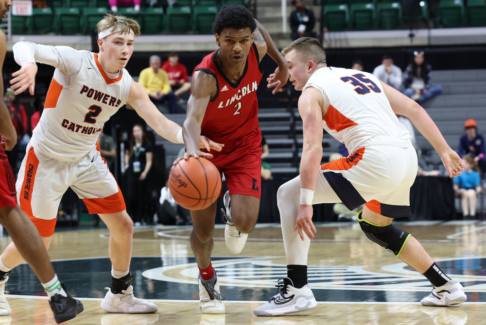 Warren Lincoln’s Markus Blackwell (2) cuts between Flint Powers Catholic defenders Grant Garman (2) and Dempsey Cull (35) during Friday’s Division 2 Semifinal. 