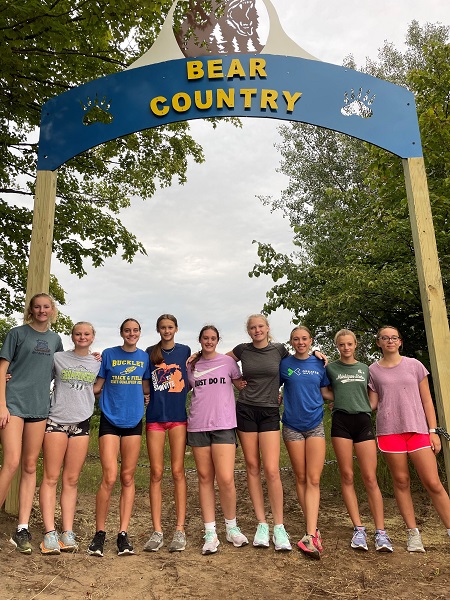 The team takes a photo in front of a new course marker. From left: Kinsey Peer, Addisen Harrand, Brooklynn Frazee, Mikayla Kulawiak, Allie Brimmer, Kayla Milarch, Aiden Harrand, Kaylee Lown and Autumn Kelsey. Missing: Maddie Chilson, Natalie Halloway and Matthew Bentley. 