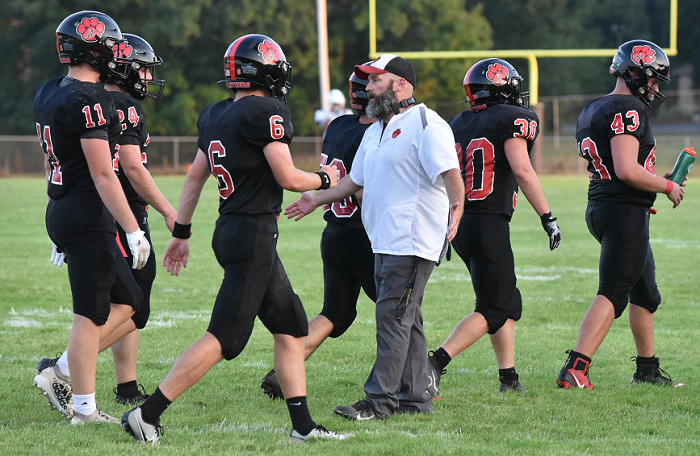 Panthers coach Joshua Lindeman greets his players before a game.