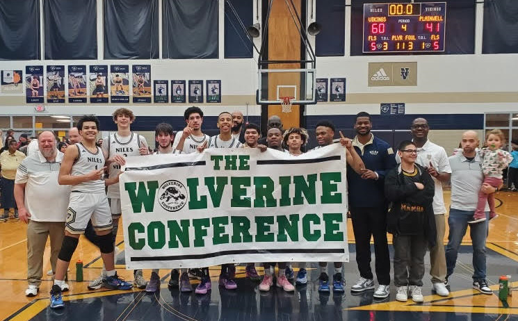 Niles players and coaches hold up the 2024 Wolverine Conference championship banner after defeating Plainwell last week. 